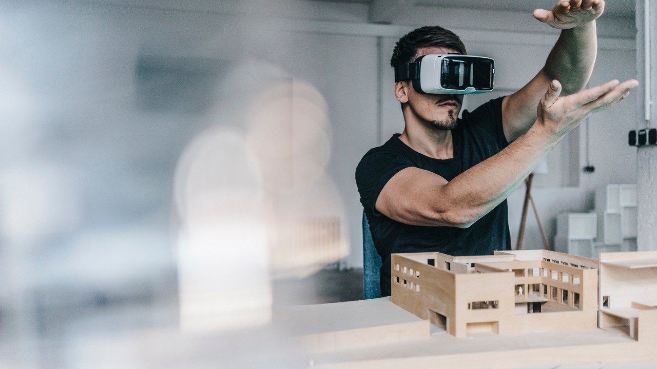 建築モデルとVRメガネを持つ男性