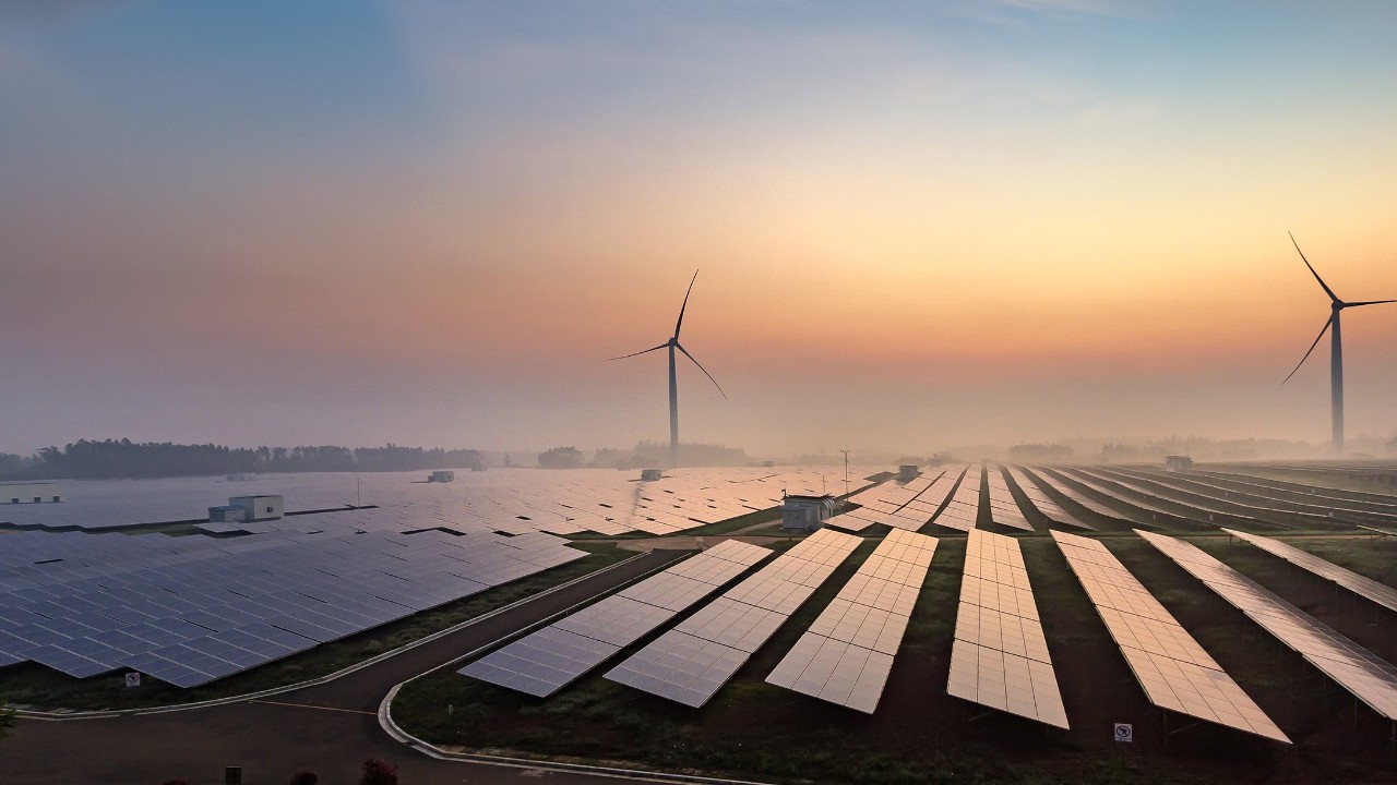 Solar and wind farm at sunrise
