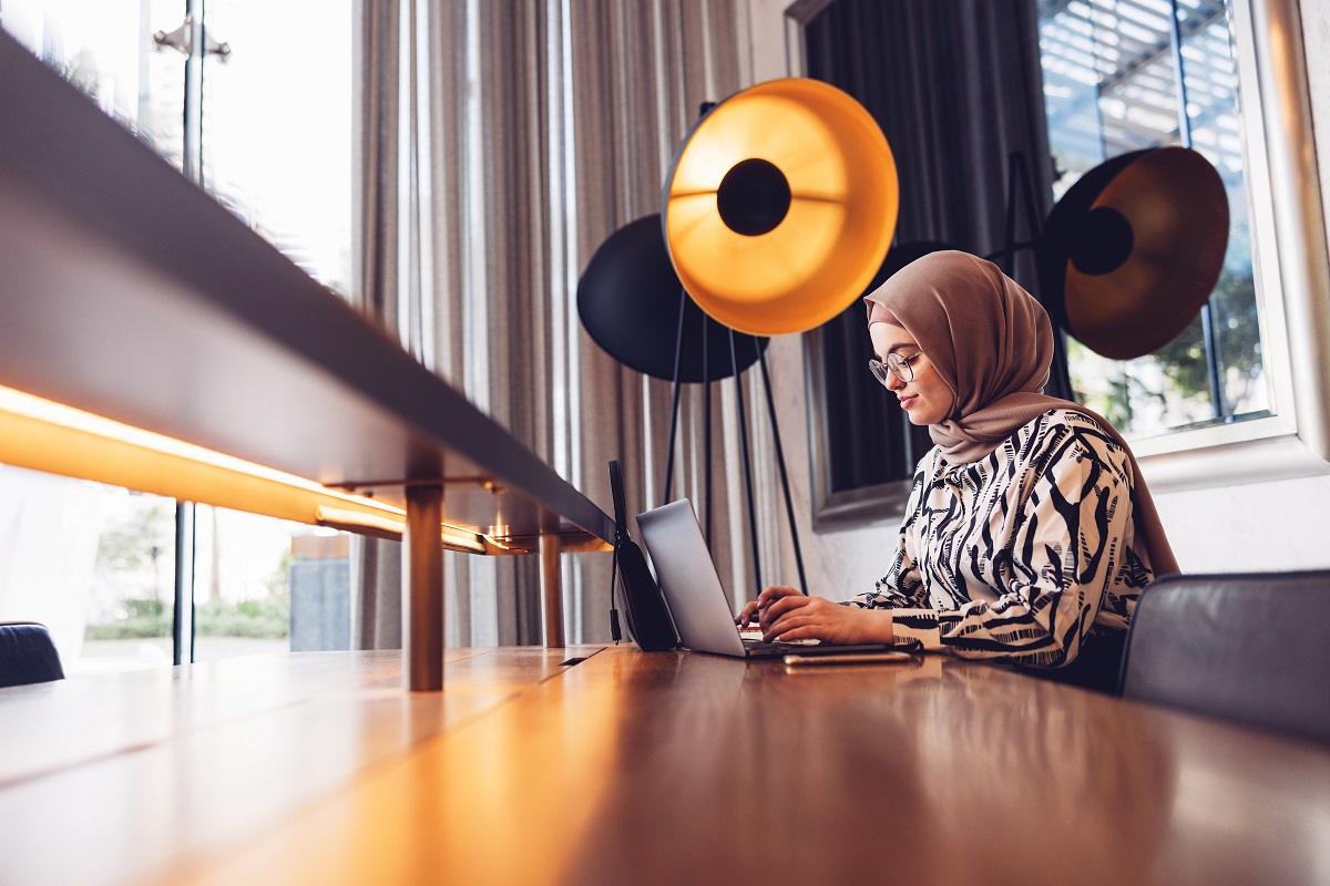 Young female entrepreneur working on a laptop while seated at a luxury hotel lounge