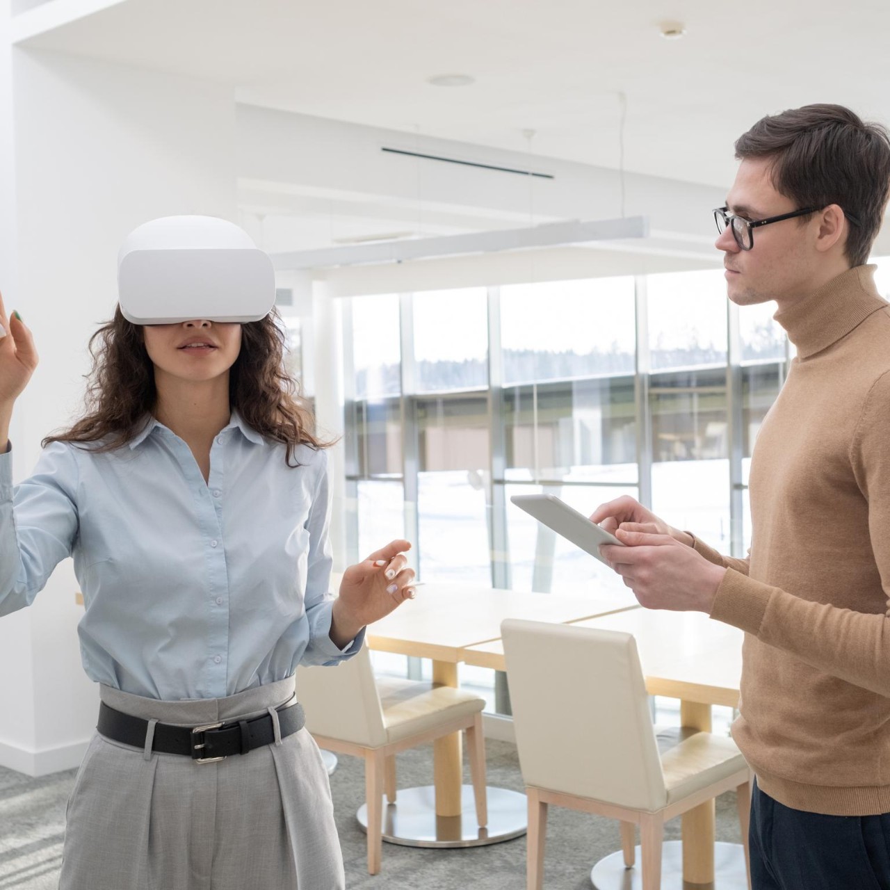 Young female developer making a presentation to colleague with tablet