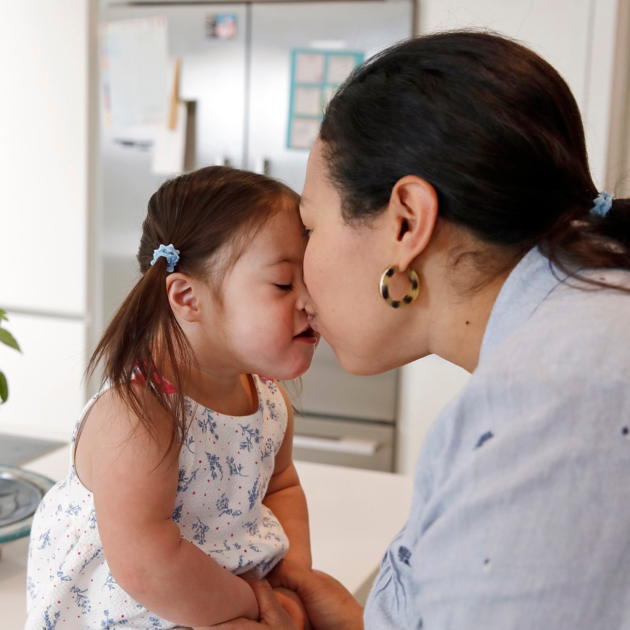 Mother and daughter in kitchen, affectionate, cute, love