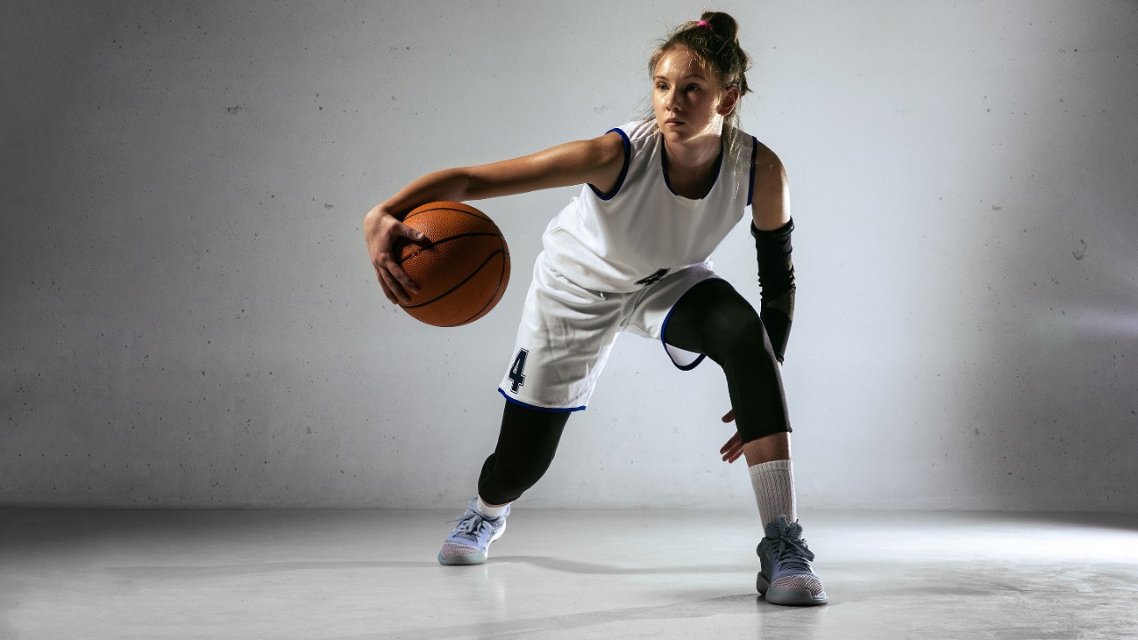 Młoda dziewczyna grająca w koszykówkę