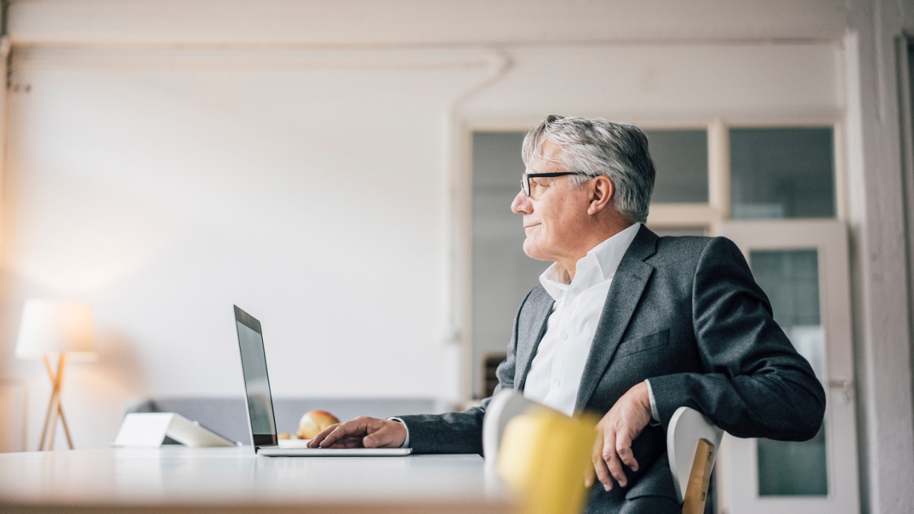 Confident senior businessman using laptop