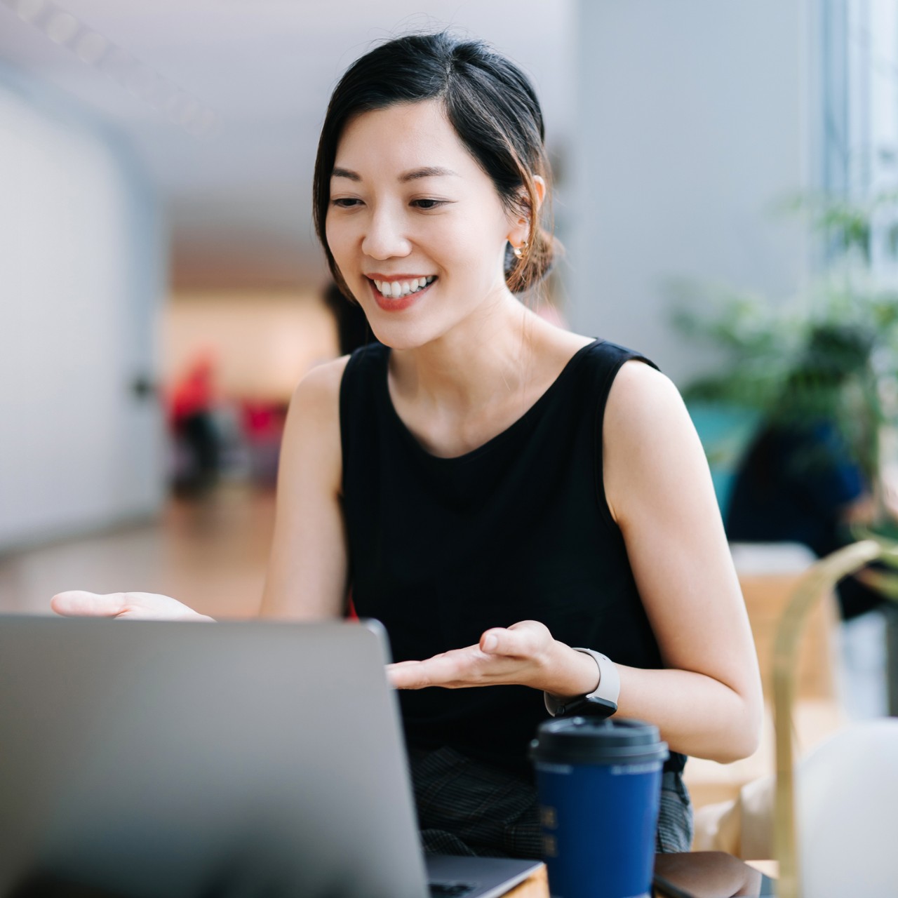 A smiling young professional video conferencing on a laptop